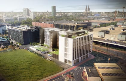 Vogelperspektivische Visualisierung eines Neubauensembles mit begrünten Dachterrassen, im Hintergrund ein Stadtpanorama mit gotischer Kathedrale.